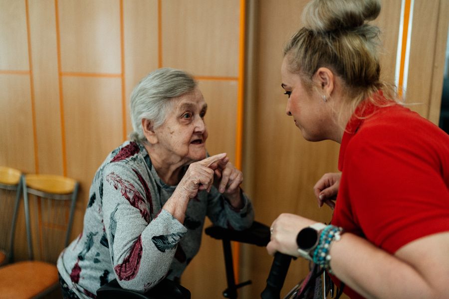 A caregiver talking with an elderly woman