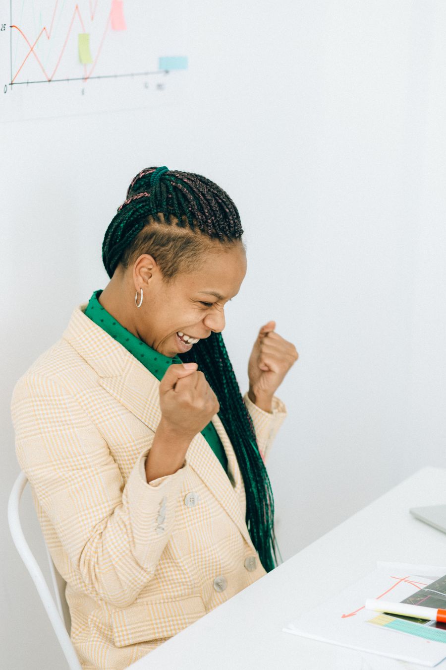 A young woman celebrating good news at her desk